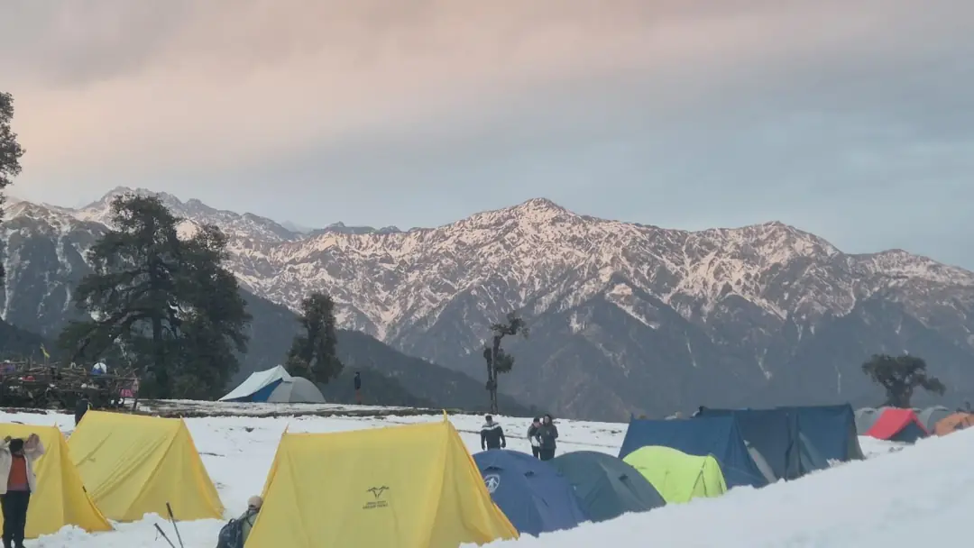Tents at dawn with the peaks behind